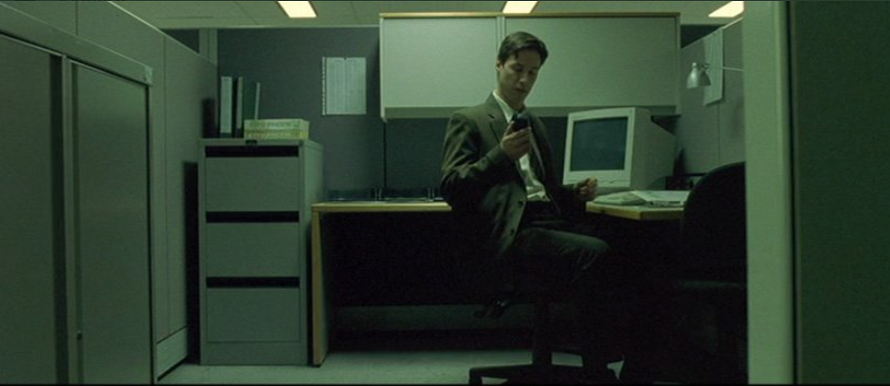 Neo in his cubicle